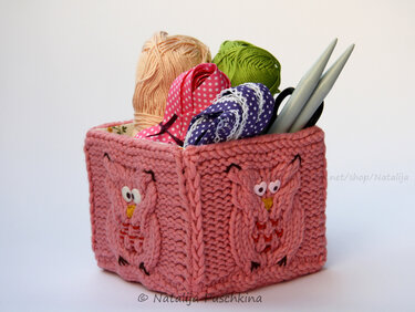 Rosa gestrickter Korb mit Eulenapplikationen, gefüllt mit Garn, Bändern und Stricknadeln