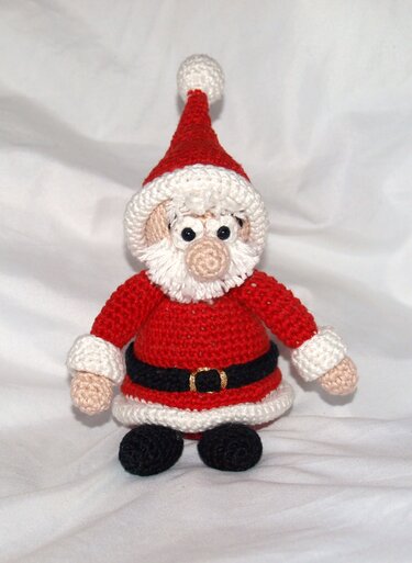 Gehäkelter Amigurumi-Weihnachtsmann in Rot und Weiß auf weißem Hintergrund