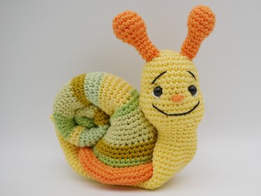 Gehäkelte Schnecke Amigurumi gelber Körper gestreifte Schale