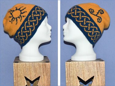 Gestrickte Beanie-Mütze in Gelb und Blau mit verschlungenem Musterband und Sonnenmotiv auf Schaufensterkopf