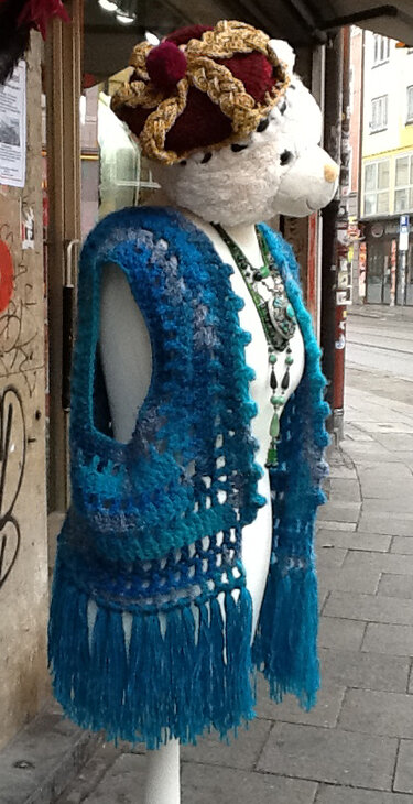 Schaufensterpuppe mit gehäkelter Weste in Blau-Türkis, Fransen und gestricktem Hut