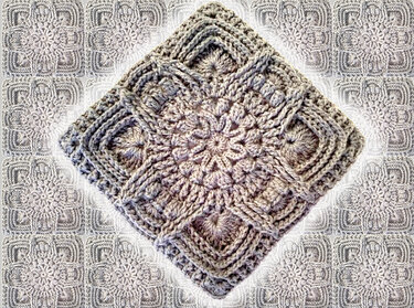 Hellgraues gehäkeltes Granny Square mit reliefartigem Blumenmittel, diagonal ausgerichtet.