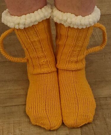 Gelbe wadenhohe Stricksocken mit weißem Plüschumschlag und seitlichen Henkel‑Schlaufen
