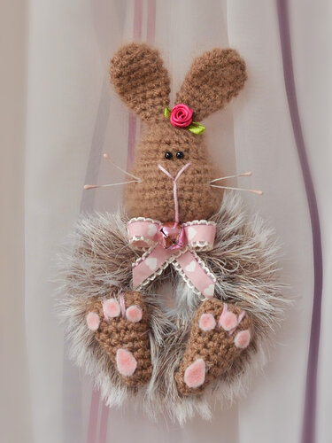 Gehäkelter brauner Osterhase mit rosa Schleife, Glöckchen, Rose am Ohr und flauschigem Kunstfellkranz.