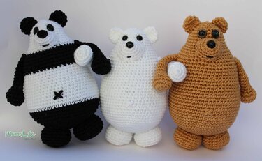 Drei gehäkelte Amigurumi-Bären nebeneinander: Panda (schwarz-weiß), Eisbär (weiß) und Braunbär (braun) vor hellem Hintergrund.