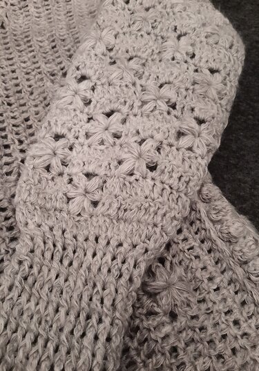 Hellgraues Häkelgewebe mit Sternchen- und Netzmuster