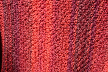 Nahaufnahme gestrickter Pullover in Rot mit strukturiertem Maschenbild