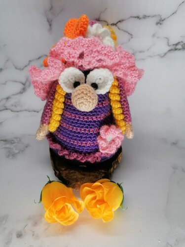 Gehäkelte Amigurumi-Puppe mit rosa Rüschenhut, lila Streifen und gelben Zöpfen