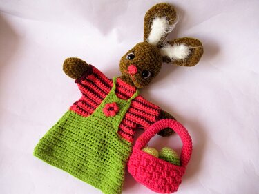 Gehäkelte Hasen-Handpuppe mit grünem Latzkleid und pinkem Häkelkörbchen mit Eiern