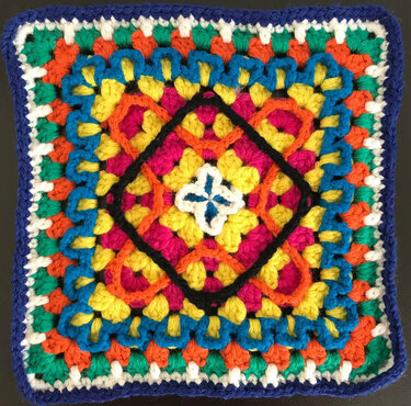 Quadratische Häkelapplikation (Granny-Square) in lebhaften Farben mit dunkelblauem Rand
