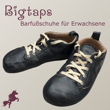Zwei dunkle Barfußschuhe mit hellen Schnürsenkeln und beigem Innenfutter auf hellem Hintergrund.