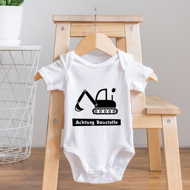 Weißer Babybody mit einfarbigem Bagger-Motiv und Schrift 'Achtung Baustelle'
