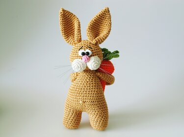 Gehäkelter Amigurumi-Hase mit großen Ohren, rosa Nase und Karotte