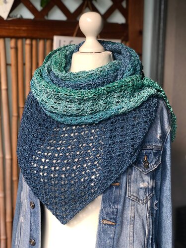 Gehäkeltes Dreieckstuch mit Blau
Grün
Farbverlauf auf einer Schneiderpuppe mit Jeansjacke