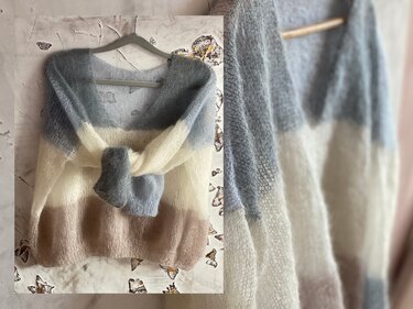 Pale blue, cream, and light brown striped fuzzy knit sweater tied at the front on a hanger.