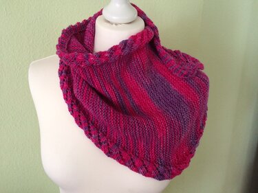 Gestricktes dreieckiges Tuch in Pink und Lila auf einer Schaufensterbüste