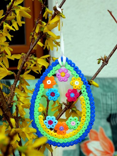 Osterei-Anhänger aus Bügelperlen mit Blumen an Forsythienzweig