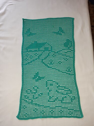 Türkisfarbener gehäkelter Tischläufer im Filetmuster mit Flugzeugmotiven auf hellem Untergrund