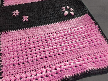 Gehäkelter Tischläufer in Pink und Schwarz mit Blüten- und Pfotenapplikationen