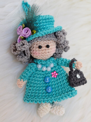 Kleine gehäkelte Puppe mit Aufhängeschlaufe, Perlenverzierung und Tasche