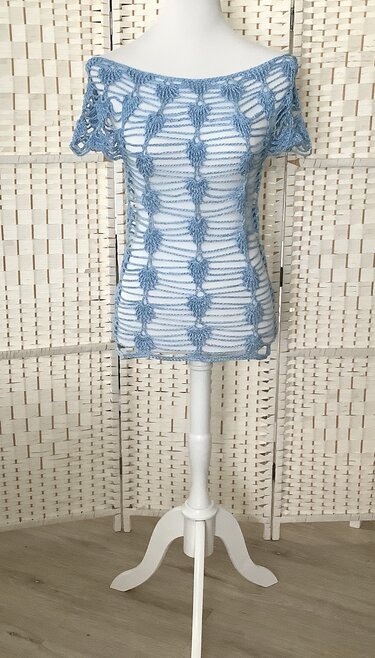 Hellblaues, offenes gehäkeltes Damen-Top mit kurzen Ärmeln auf Schaufensterpuppe
