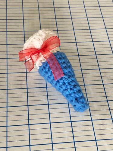 Schnell gehäkelte Mini-Schultüte in Eistütenform, blau mit roter Schleife