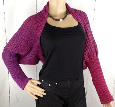 Gestrickter Damen‑Bolero in Lila‑Pink mit langen Ärmeln auf Schaufensterpuppe