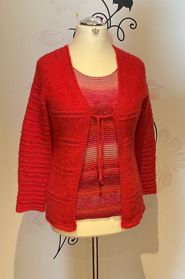 Rote gestrickte Damenjacke mit Bindeband und 3/4-Ärmeln auf Schneiderpuppe