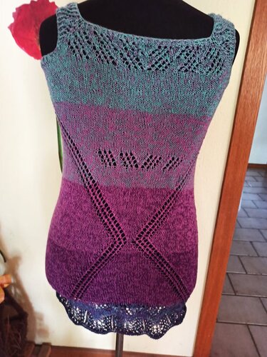 Ärmelloses gestricktes Damen‑Shirt in Türkis, Pink und Violett mit dekorativen Lochmustern und welligem Saum.