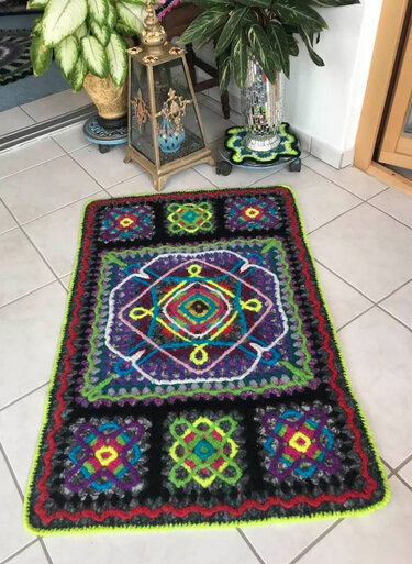 Gefilzter Häkelfilzteppich mit zentralem Quadrat und bunten Randfeldern