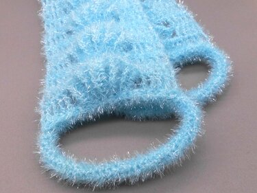 Compact pale blue crochet pad with two finger loop handles and fuzzy eyelash yarn texture