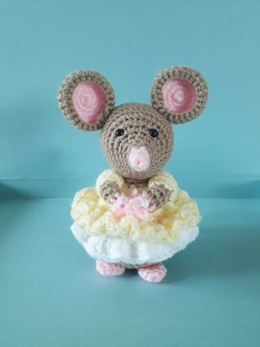 Nahaufnahme einer gehäkelten Amigurumi-Maus mit rosa Innenohren und gestuftem Rüschenrock