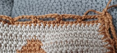 Nahaufnahme gehäkelter Topflappen creme und hellbraun mit Randborte