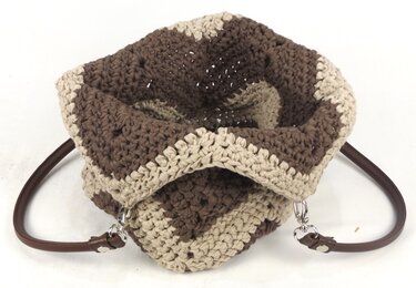 Gehäkelte Umhängetasche in Braun und Beige mit Zickzack-Muster, Draufsicht, braune Griffe mit silbernen Karabinern