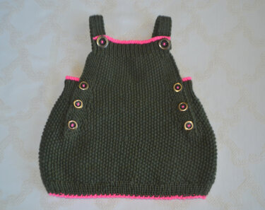 Dunkelgrüner gestrickter Babystrampler mit pinken Zierkanten und Schulter- sowie Seitenknöpfen