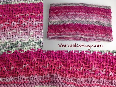 Nahaufnahme eines gestrickten Loop‑Schals in Rosa, Weiß und Grau mit sichtbarer Textur