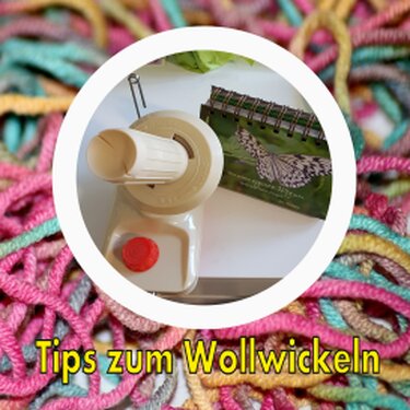Mechanischer Wollwickler mit rotem Knopf neben Notizbuch und buntem Garn