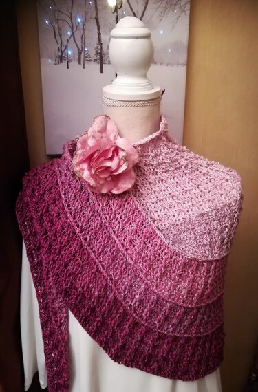 Asymmetrisches gehäkeltes Dreieckstuch in abgestuften Rosa- und Burgundtönen auf einer Schaufensterpuppe