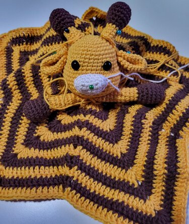 Unfertiges gehäkeltes Babyschmusetuch mit Giraffenkopf und braun-gelbem Zickzackmuster