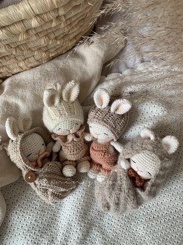 Vier Amigurumi-Hasen mit unterschiedlichen Ohren- und Mützendesigns und variierenden Texturen