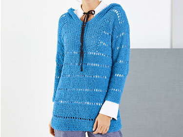 Langer blauer Häkel-Kapuzenpullover mit Lochstreifen und dunkler Zierkordel über weißer Bluse