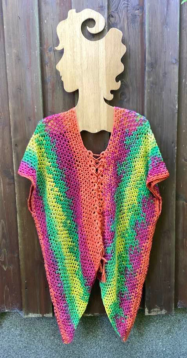 Boho-inspirierte bunte Häkel-Tunika mit vorderer Schnürung auf Holzschaufigur