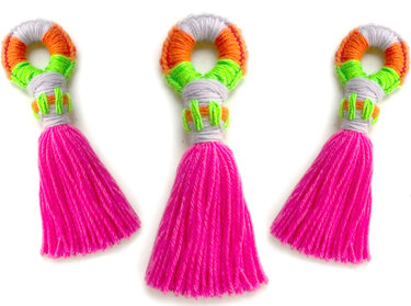 Drei mehrfarbige Garnquasten in Pink, Neon und Grau