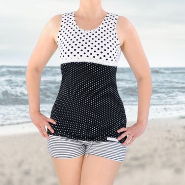 Schwarz-weiß gepunkteter Tankini mit gestreiften Shorts am Strand