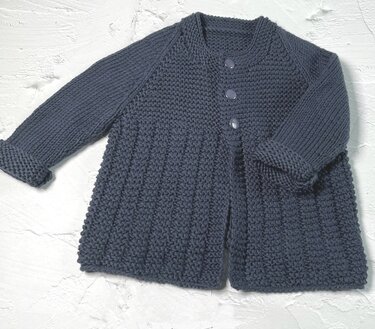 Dunkelblaue gestrickte Kinderjacke mit drei Knöpfen und strukturiertem Muster auf hellem Hintergrund.