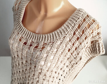 Beige crocheted openwork top with round neckline and short sleeves on a dress form.