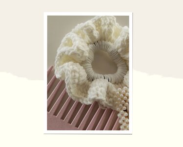 Cremefarbenes gehäkeltes Haargummi mit Rüschen auf rosa Kamm neben Perlen