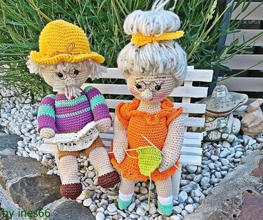 Gehäkeltes Amigurumi-Großelternpaar auf weißer Holzbank