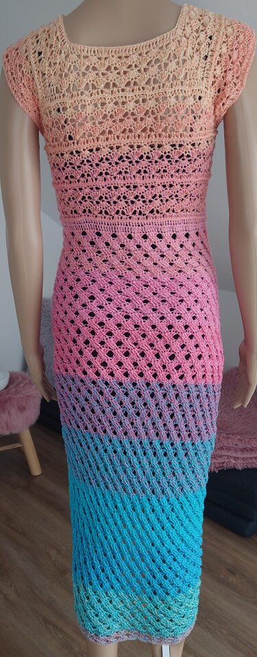 Vollansicht eines langen gehäkelten Kleids auf Mannequin mit gestaffeltem Lochmuster und Farbverlauf von Pfirsich bis Türkis