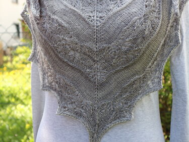 Grau gestricktes Dreieckstuch mit Blattspitze über hellem Oberteil